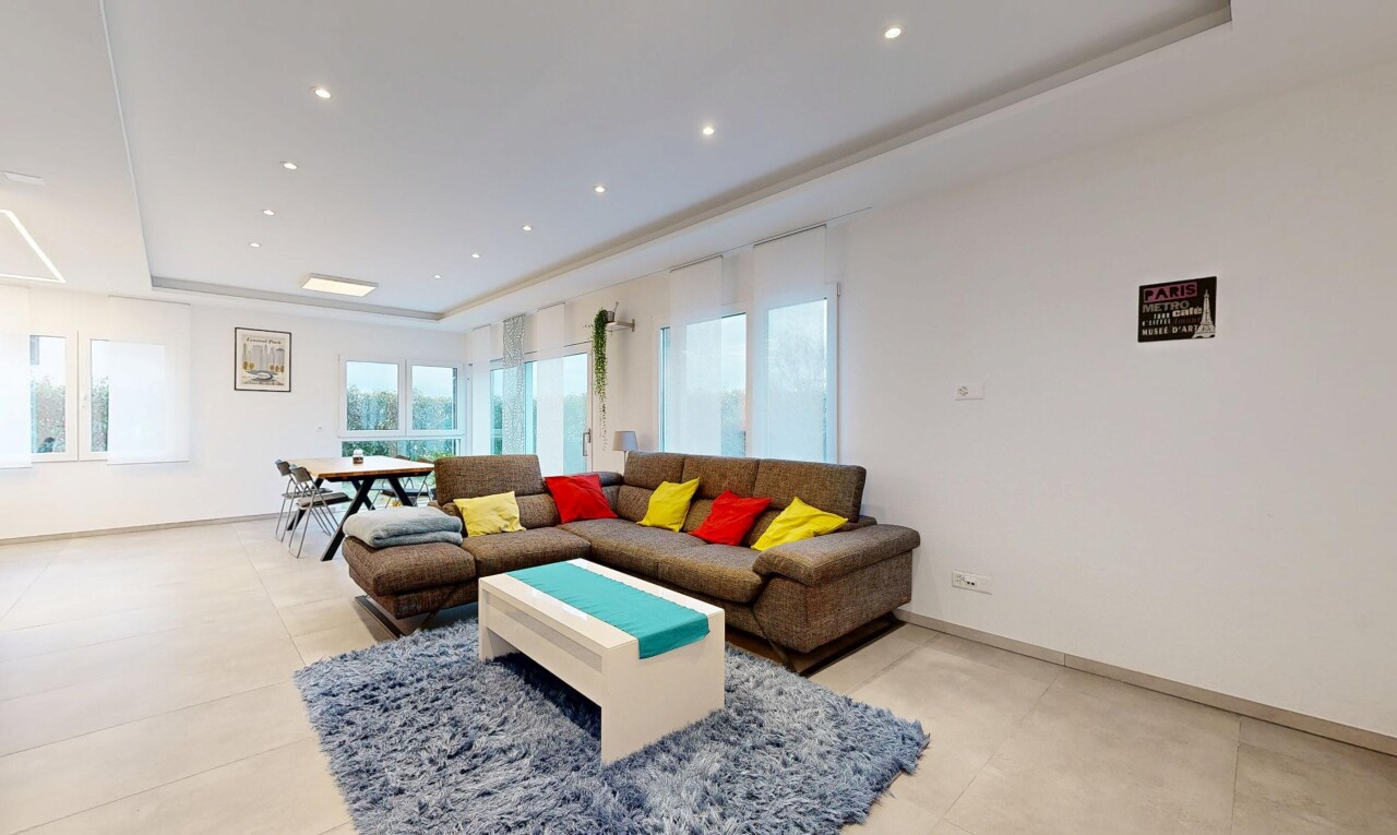 living / dining area featuring a raised ceiling and recessed lighting