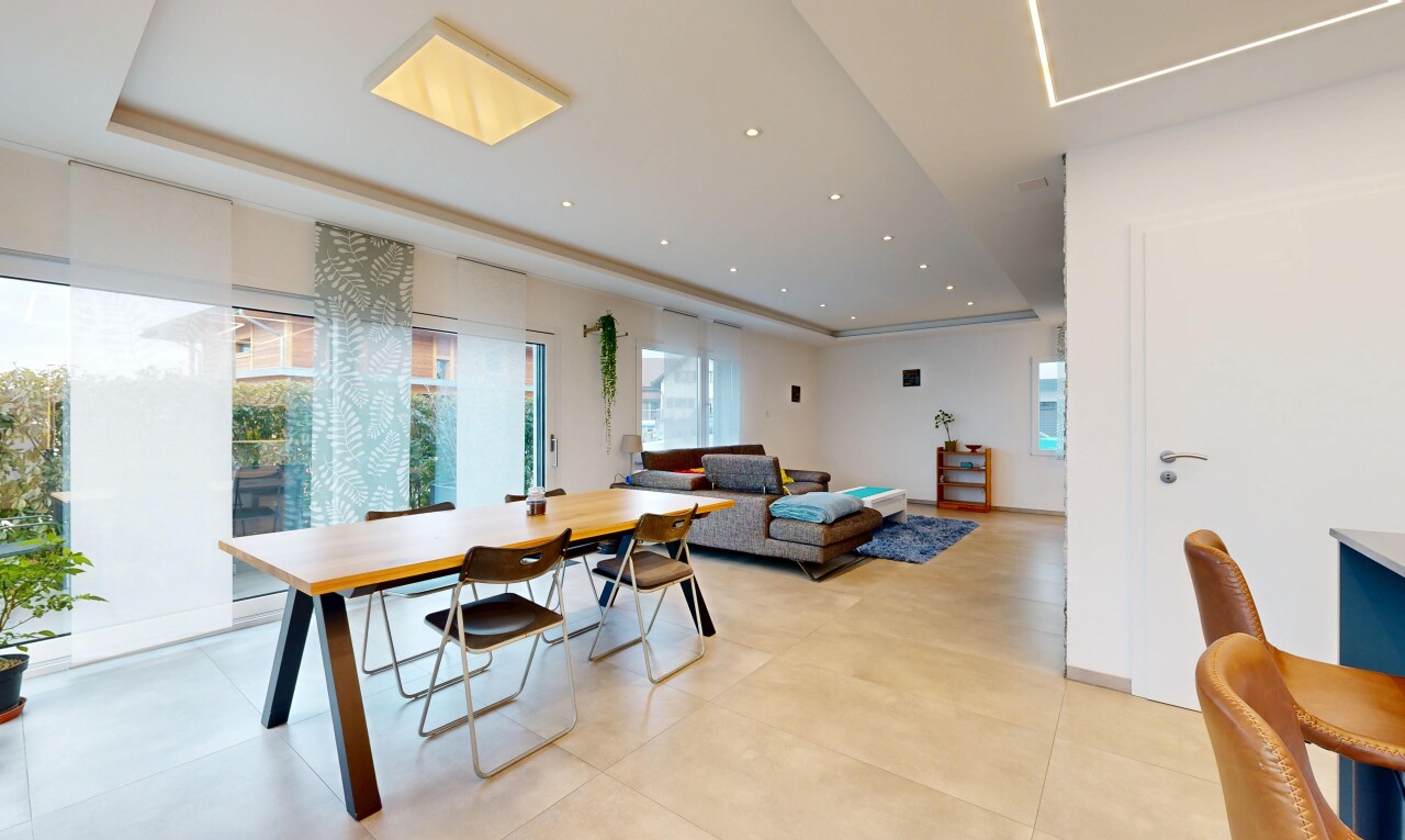 living area featuring a raised ceiling, healthy amount of natural light, and recessed lighting