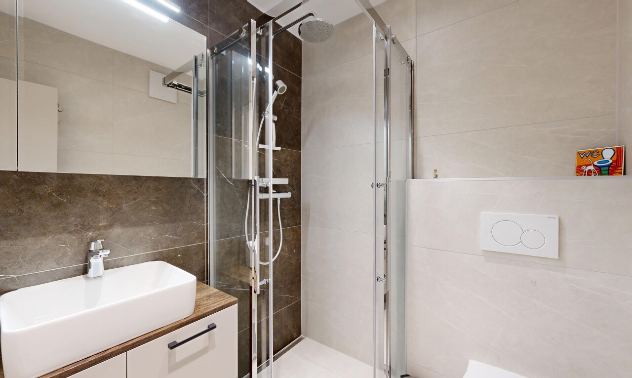 bathroom featuring vanity, tile walls, and a shower stall