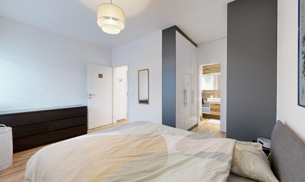 room featuring light wood-style floors and ensuite bath