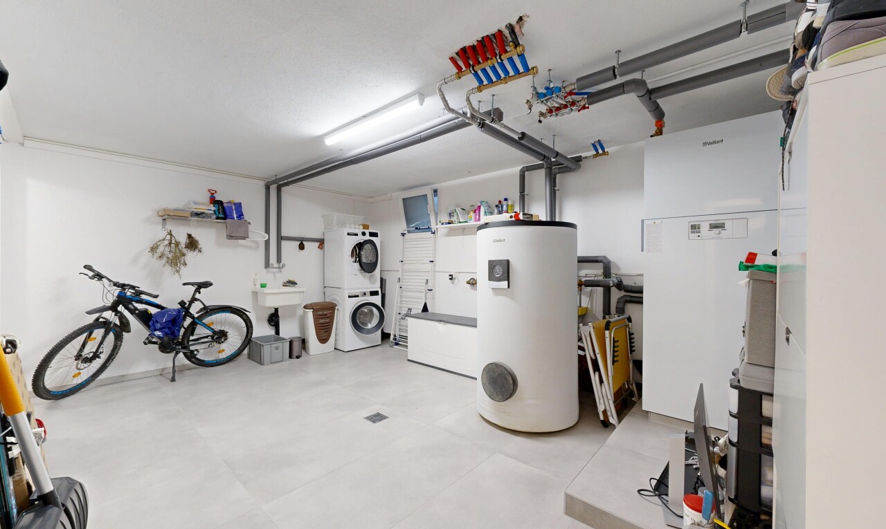 view of vehicle parking featuring water heater and stacked washer and clothes dryer