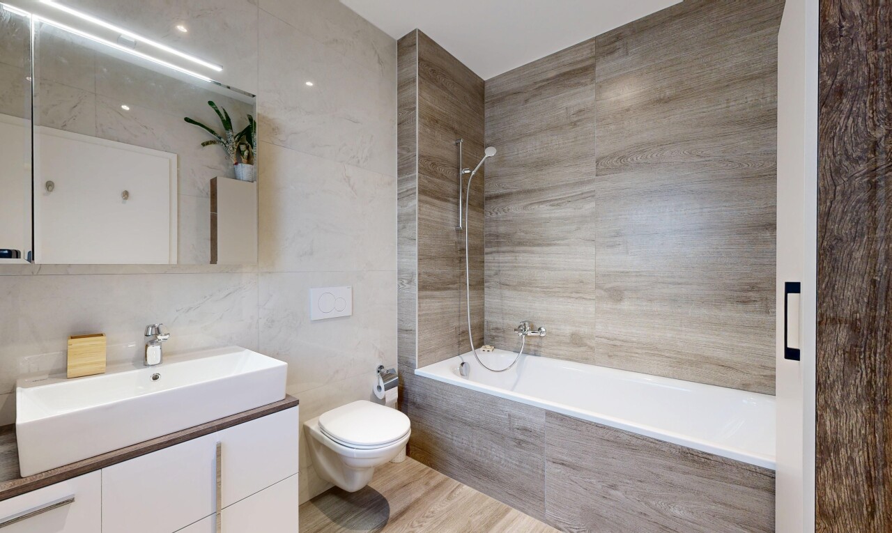 bathroom featuring tiled shower / bath combo, vanity, tile walls, and light wood-style flooring
