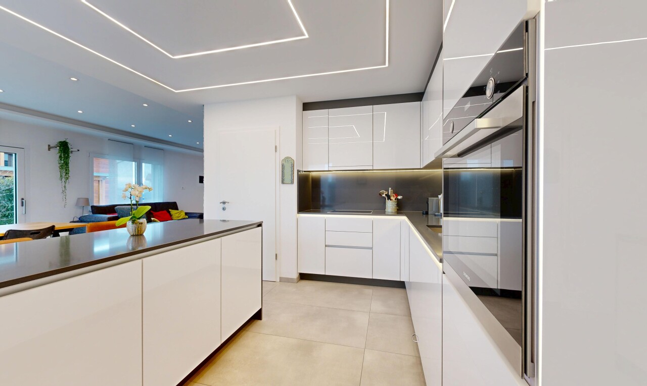 kitchen with modern cabinets, white cabinetry, oven, and backsplash