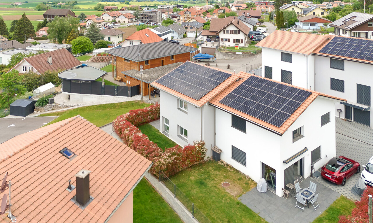 outdoor house with stucco siding, roof mounted solar panels, a patio, and a residential view