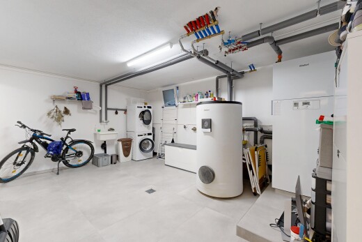 view of vehicle parking featuring water heater and stacked washer and clothes dryer