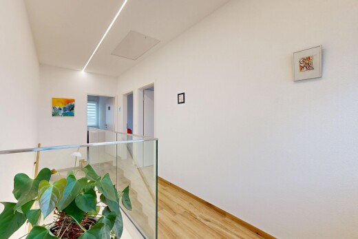 couloir avec inside property, cloison sèche, drywall, sol en finition bois, et wood finish floor