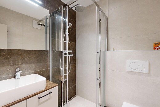 bathroom featuring vanity, tile walls, and a shower stall