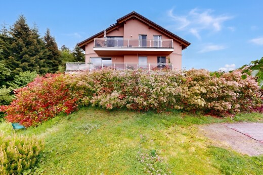 view of property featuring stucco siding, a balcony, and a lawn