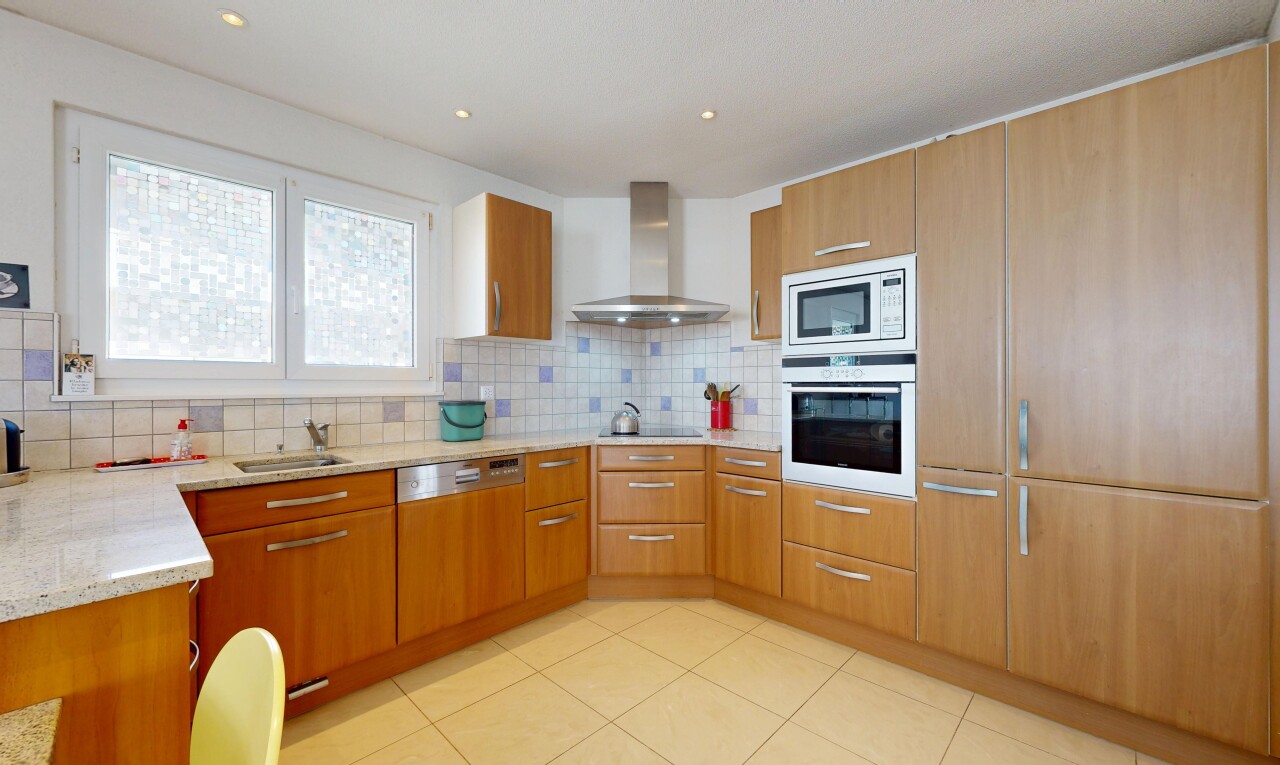 cuisine avec hotte, four, light countertops, plans de travail en pierre, et stone countertops