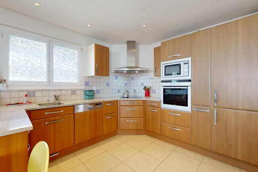 cuisine avec hotte, four, light countertops, plans de travail en pierre, et stone countertops