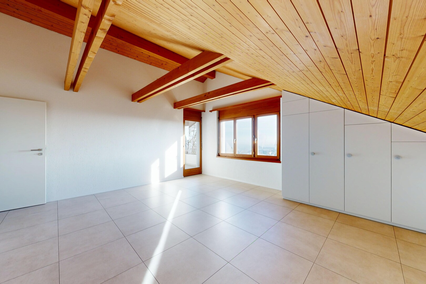 pièce vide avec plafond voûté, vaulted ceiling, light floor, inside property, et lumière naturelle