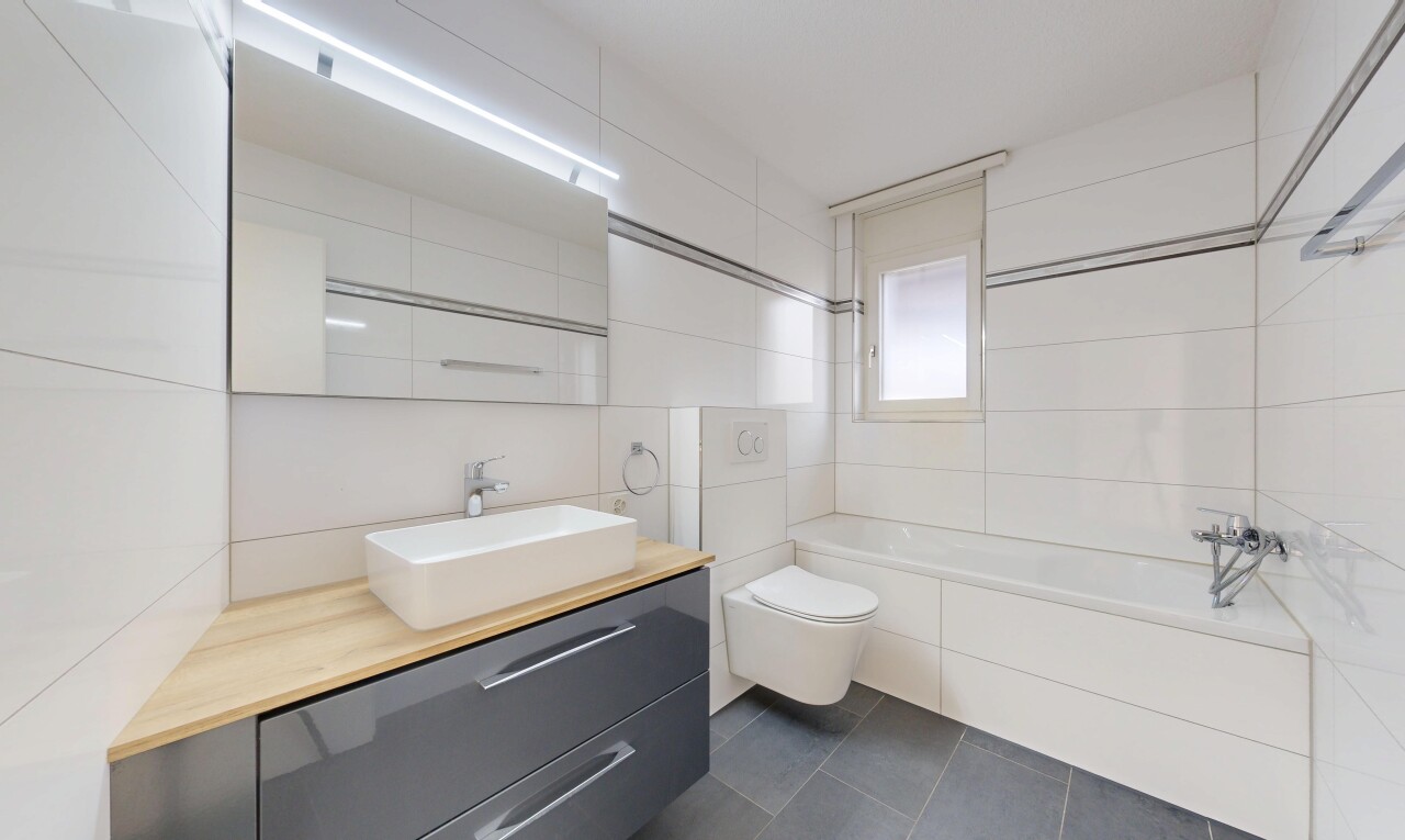 salle de bains avec mur en carrelage, tile wall, dark floor, salle de bain complète, et lavabo (ou coiffeuse selon le contexte)