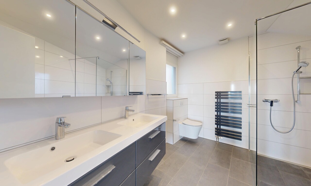 salle de bains avec douche, salle de bain complète, chauffe-serviettes, double vasque, et inside property