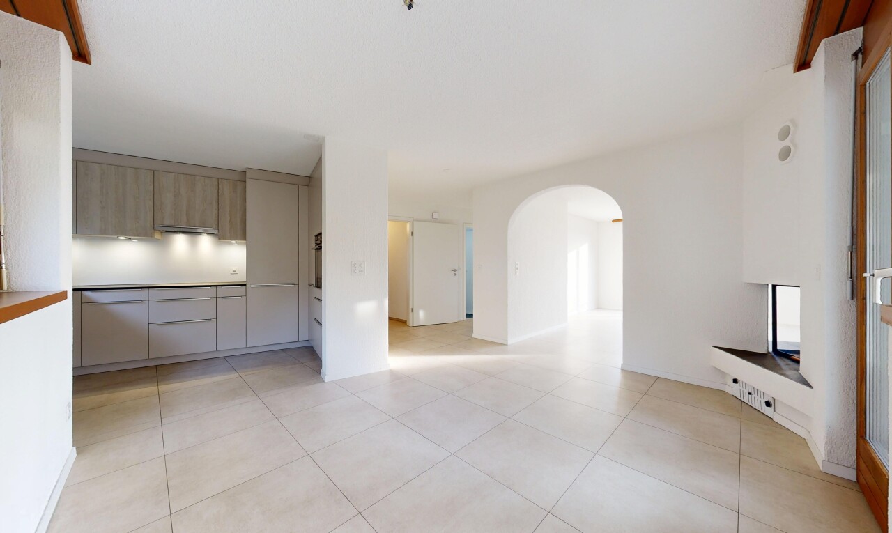 pièce vide avec light floor, passages en arc, cloison sèche, drywall, et sol en carrelage