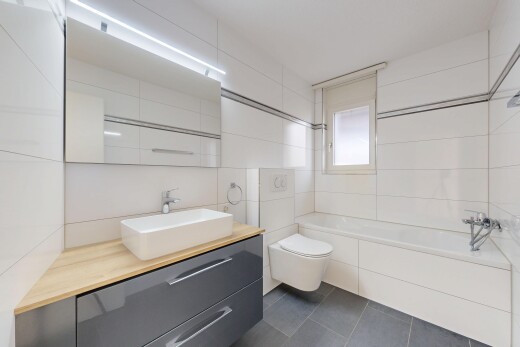 salle de bains avec mur en carrelage, tile wall, dark floor, salle de bain complète, et lavabo (ou coiffeuse selon le contexte)