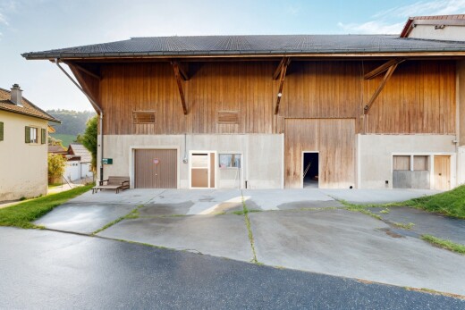 façade avec bardage en bois, bardage vertical, property visible, day time, et aire de stationnement