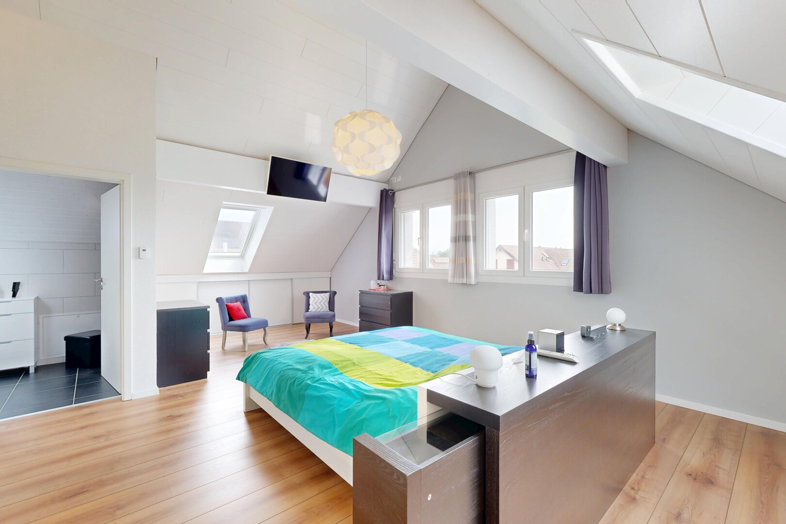 chambre avec lumière naturelle, plafond voûté, vaulted ceiling, sol en finition bois, et wood finish floor