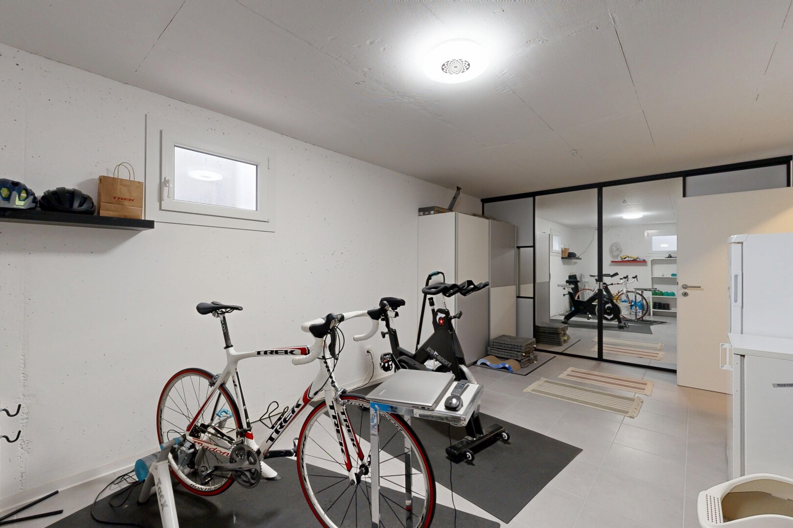 gym avec inside property, cloison sèche, drywall, lumière naturelle, et sous-sol