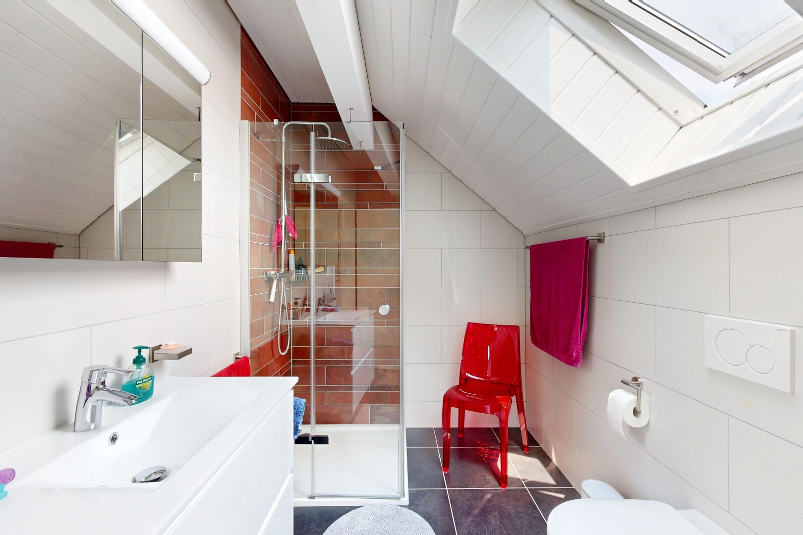 salle de bains avec plafond voûté, vaulted ceiling, lavabo (ou coiffeuse selon le contexte), mur en carrelage, et tile wall