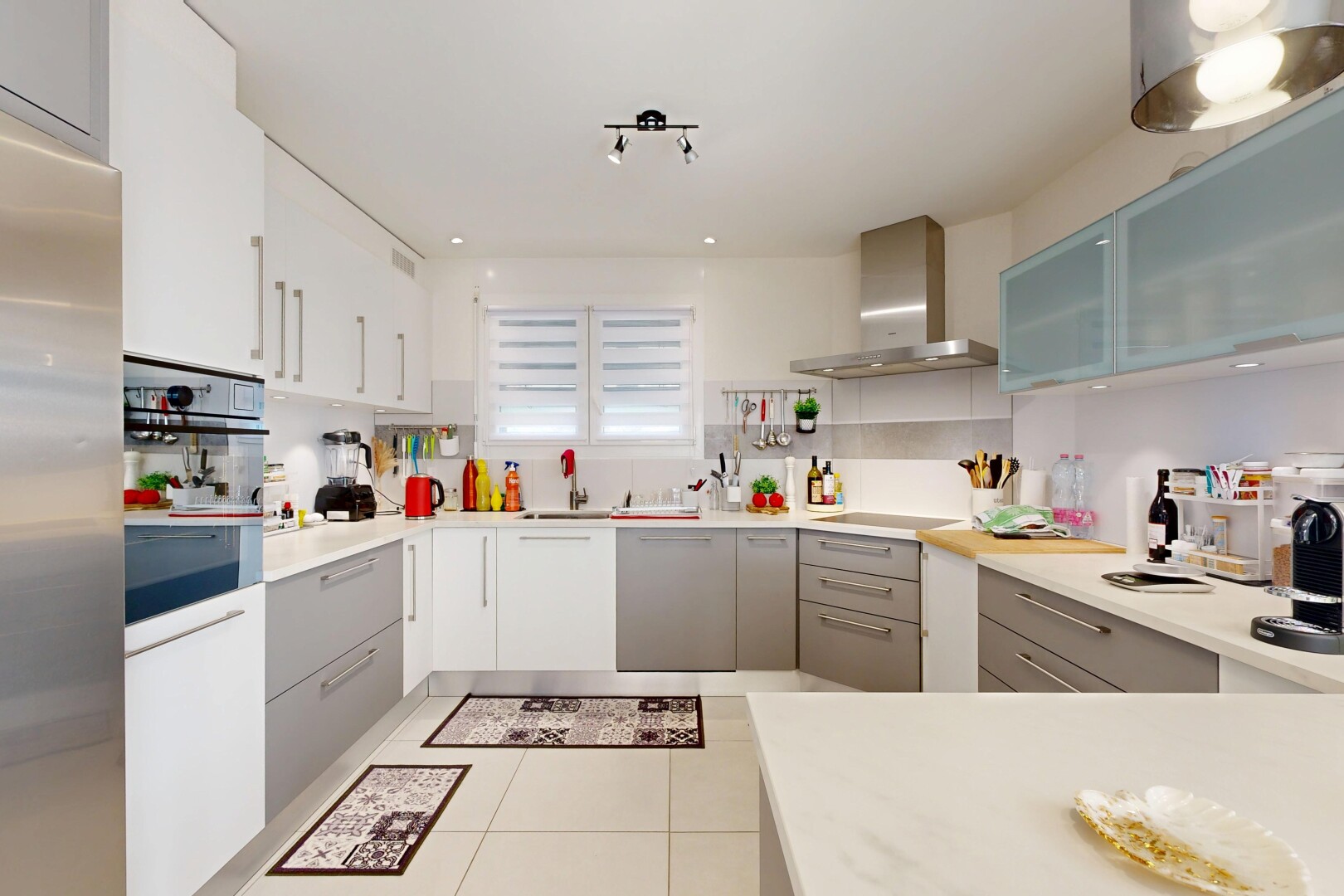 cuisine avec réfrigérateur, hotte, light countertops, plans de travail, et light floor