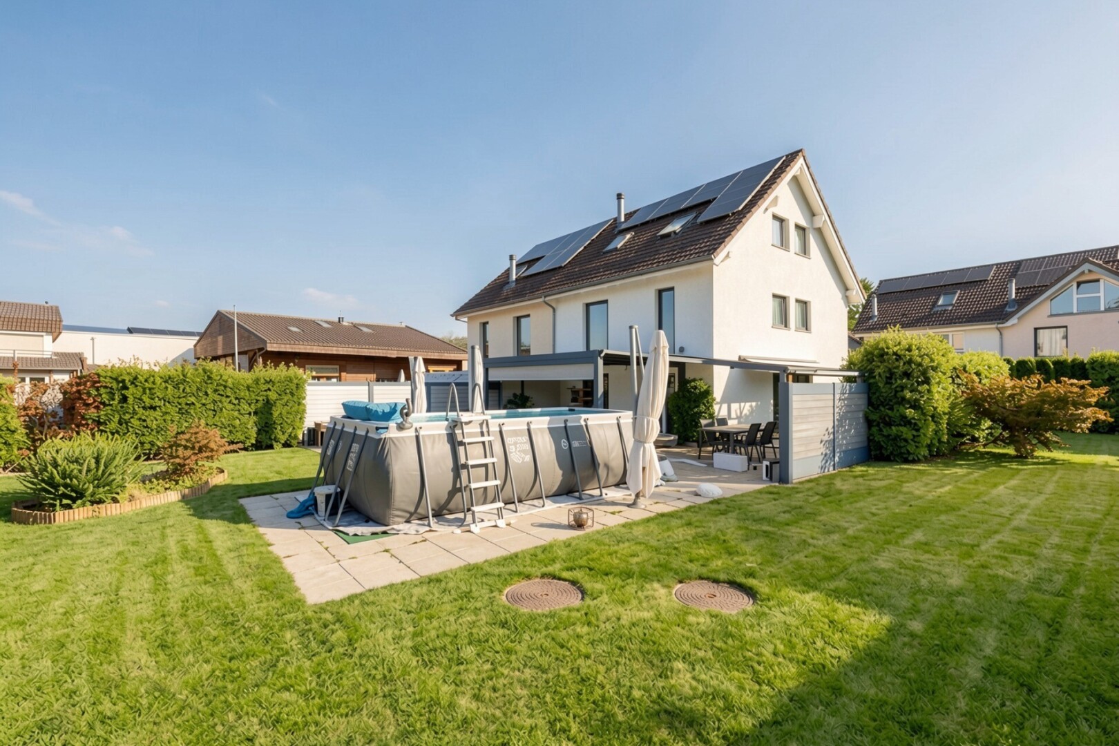 façade avec terrasse, panneaux solaires, property visible, piscine, et pelouse