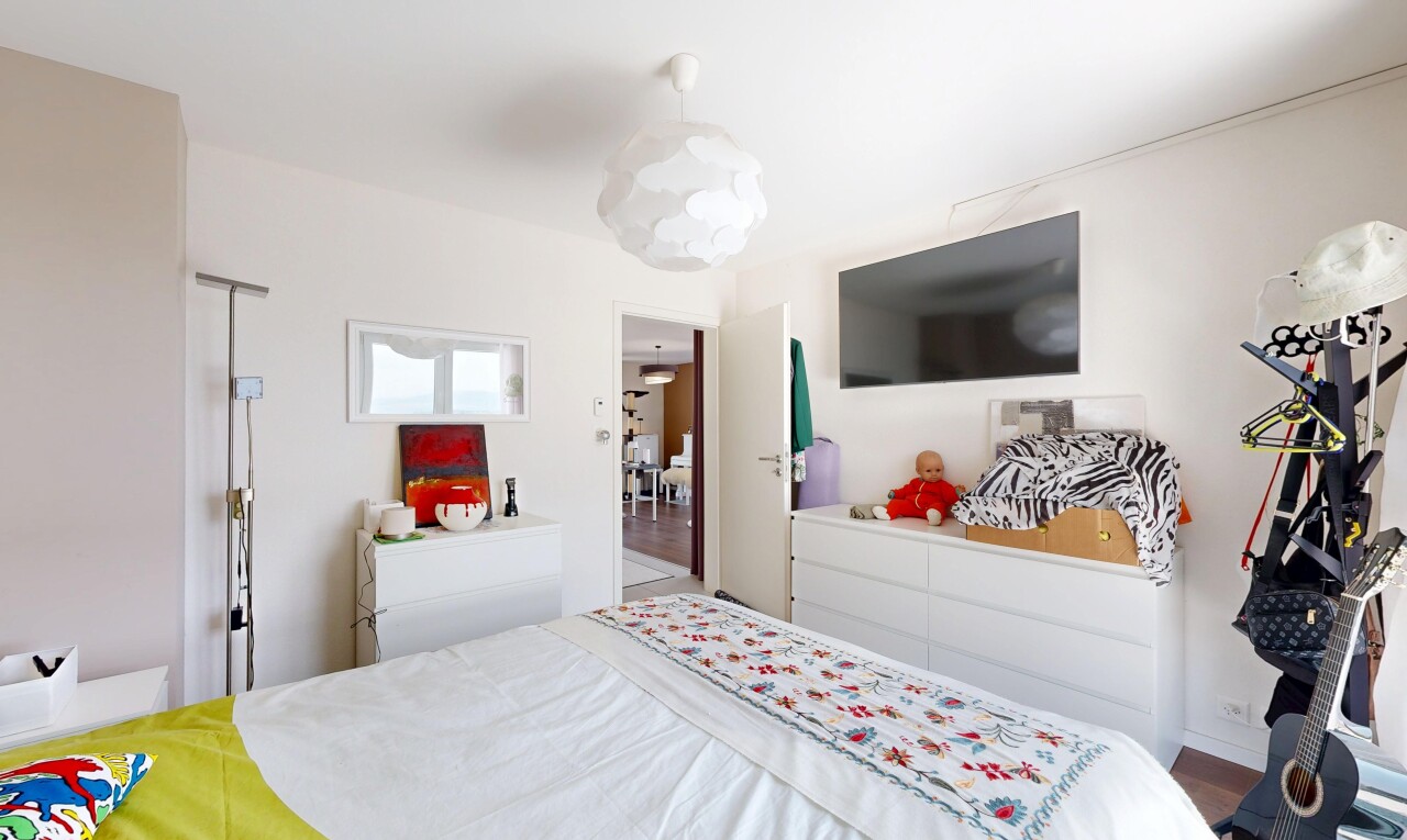 chambre avec éclairage suspendu, télévision, cloison sèche, et drywall