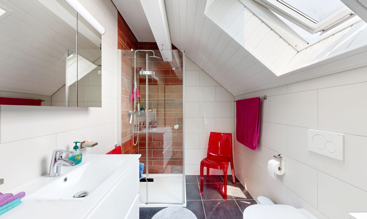 salle de bains avec plafond voûté, vaulted ceiling, lavabo (ou coiffeuse selon le contexte), mur en carrelage, et tile wall