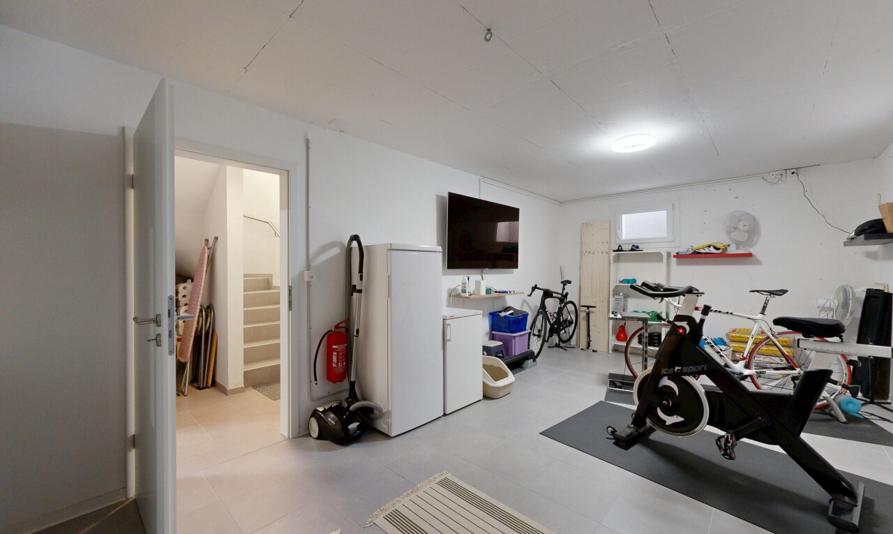 gym avec cloison sèche, drywall, télévision, et sous-sol