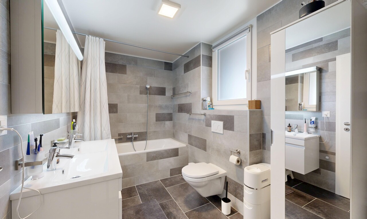 salle de bains avec miroir, lavabo (ou coiffeuse selon le contexte), mur en carrelage, tile wall, et salle de bain complète