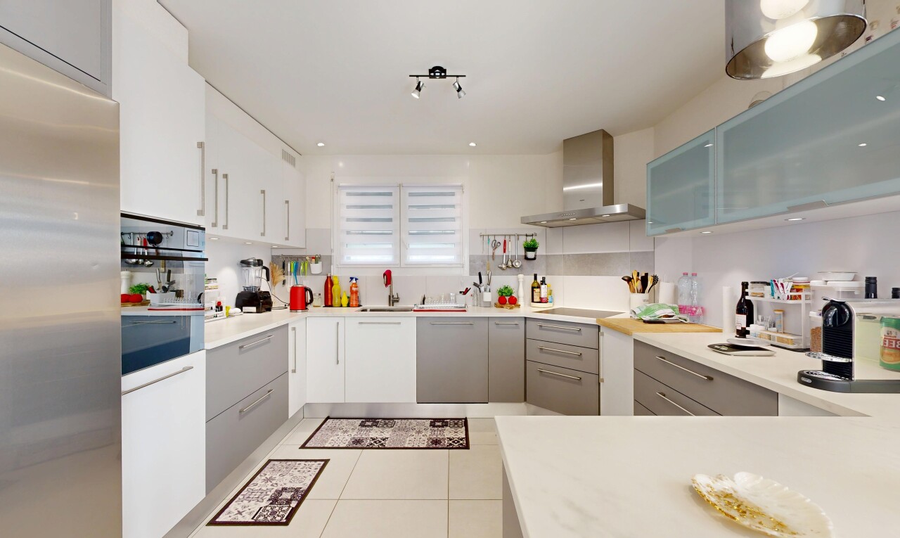 cuisine avec réfrigérateur, hotte, light countertops, plans de travail, et light floor