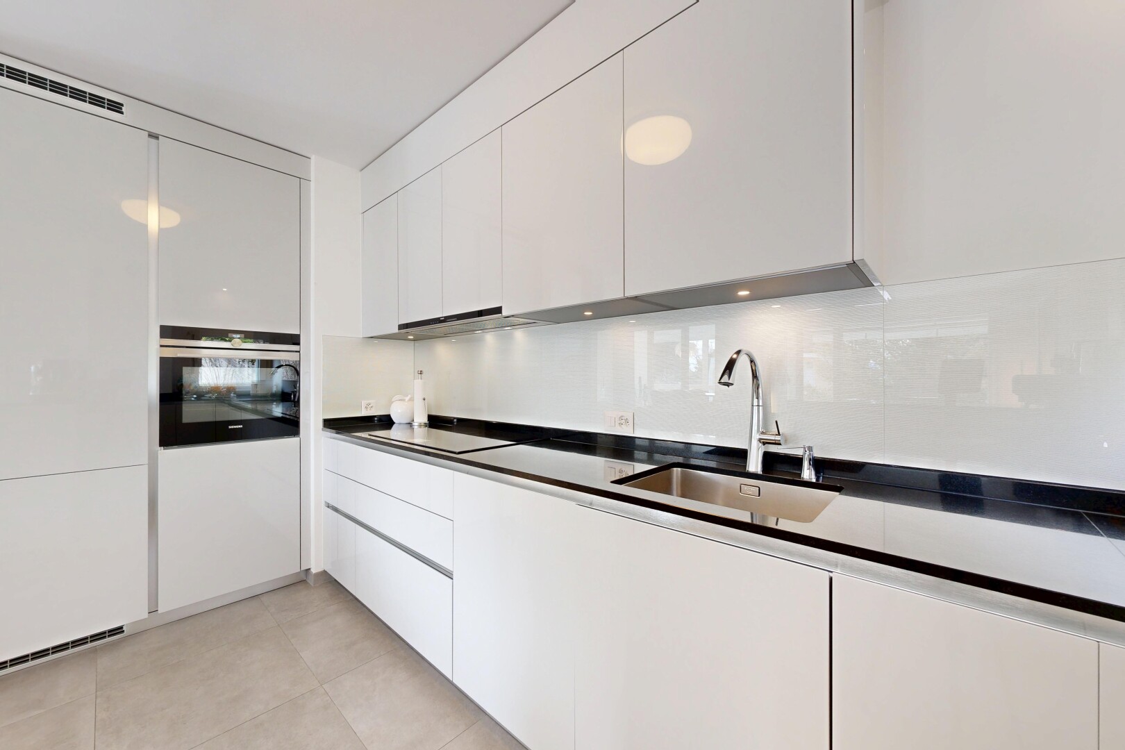kitchen featuring dark countertops, oven, white cabinetry, and modern cabinets