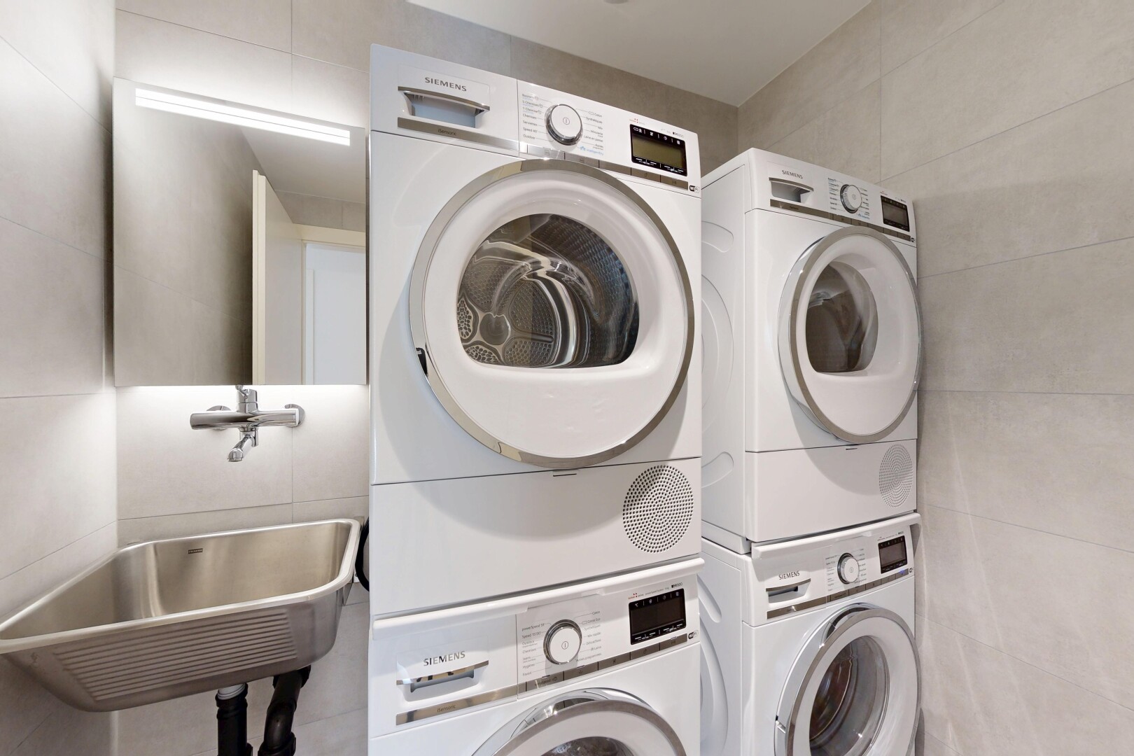 laundry room with tile walls and stacked washer / drying machine