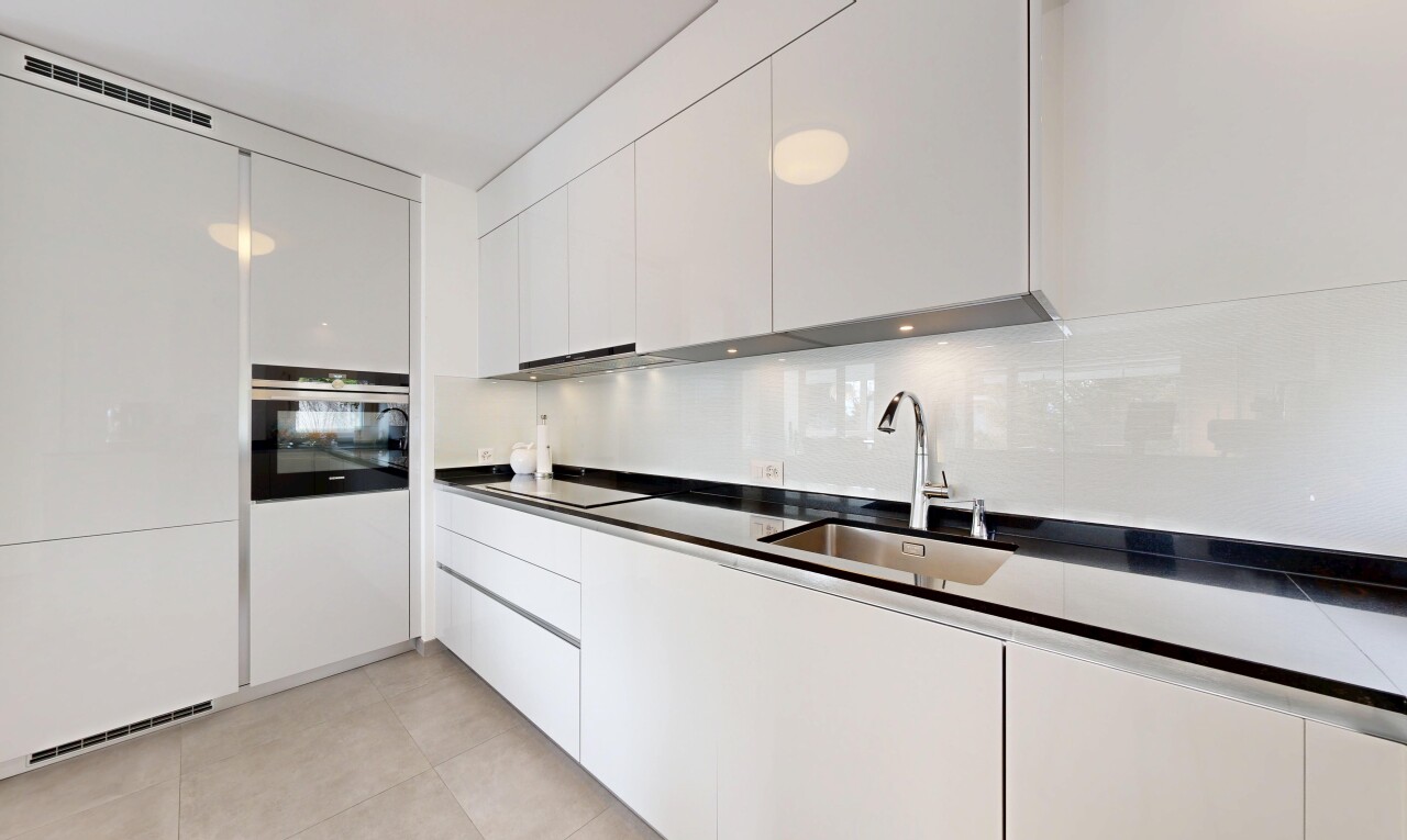 kitchen featuring dark countertops, oven, white cabinetry, and modern cabinets