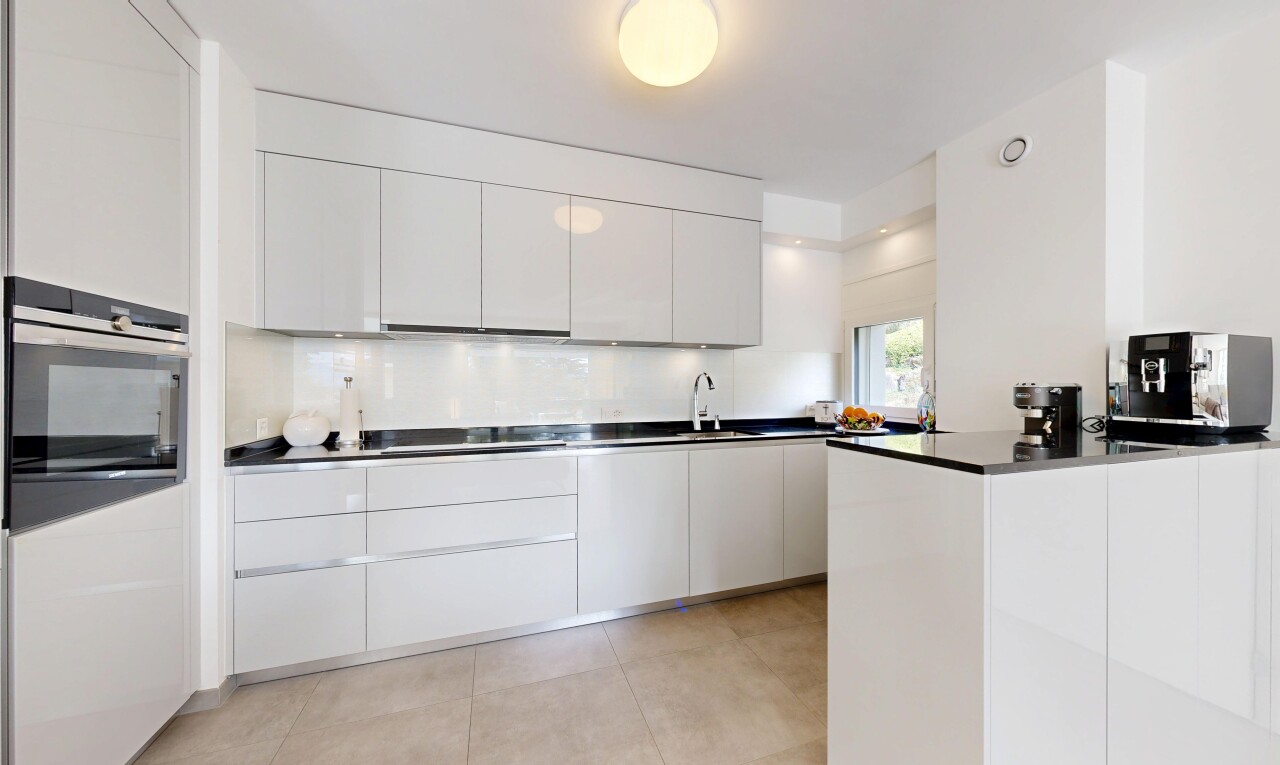 kitchen with modern cabinets, white cabinets, stainless steel appliances, and dark countertops