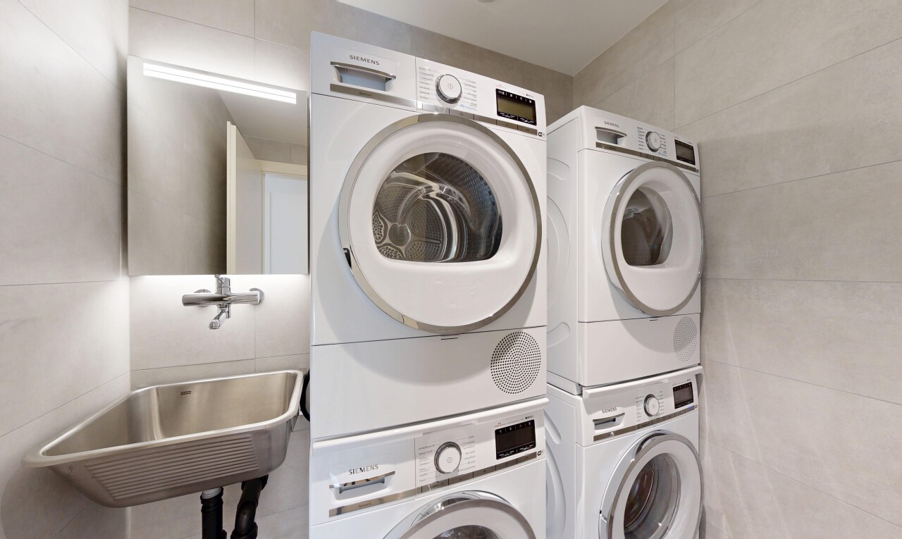 laundry room with tile walls and stacked washer / drying machine