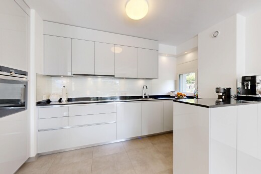 kitchen with modern cabinets, white cabinets, stainless steel appliances, and dark countertops