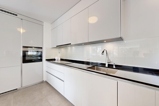 cuisine avec plans de travail, dark countertops, light floor, four, et armoires blanches