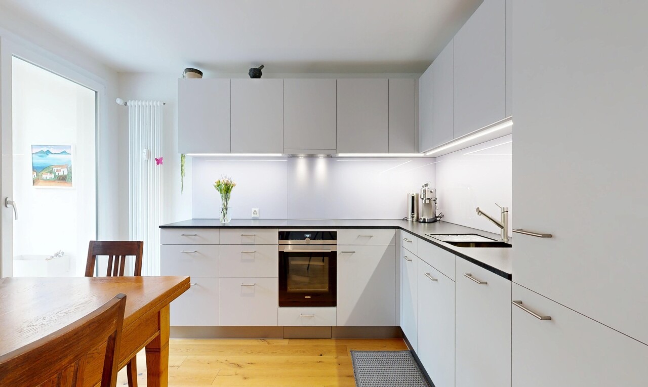 cuisine avec four, light floor, wood finish floor, sol en finition bois, et white cabinets