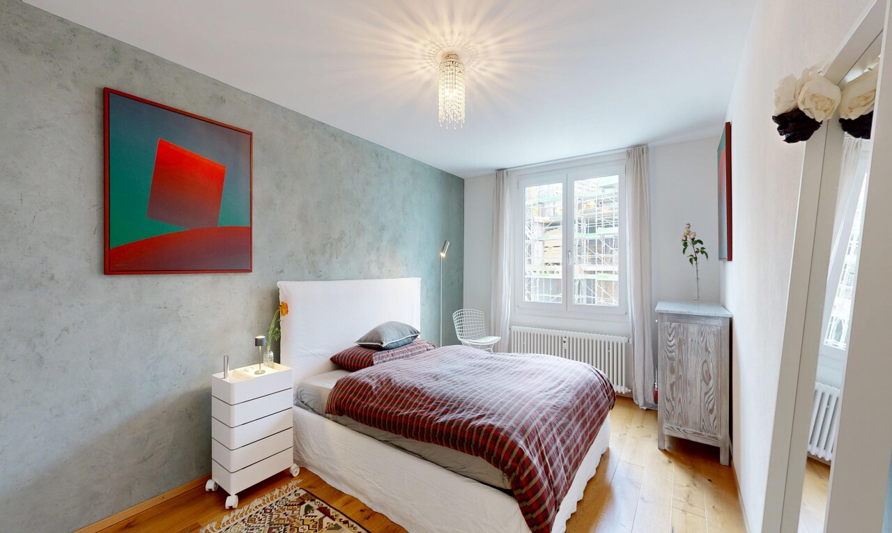 chambre avec sol en finition bois, wood finish floor, radiateur, lumière naturelle, et natural light