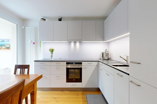 cuisine avec four, light floor, wood finish floor, sol en finition bois, et white cabinets