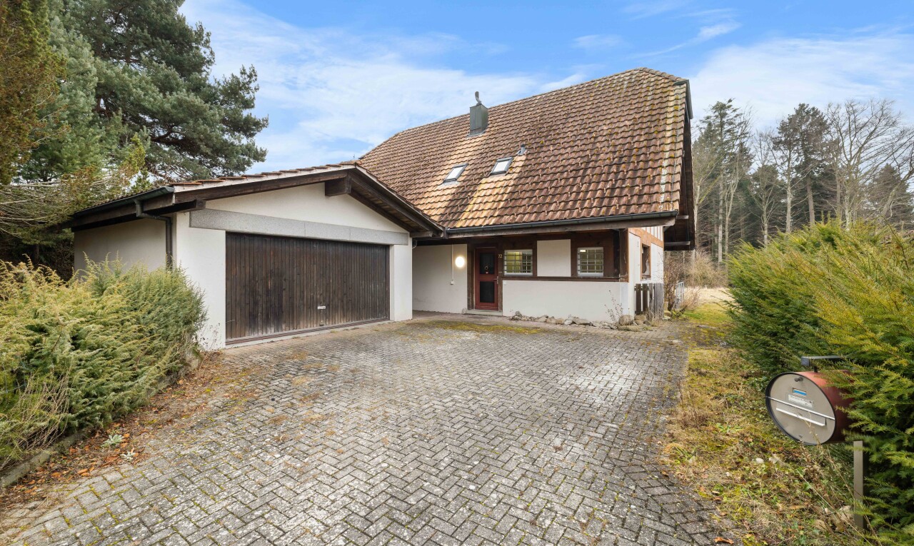 außenansicht mit garage angeschlossen, stuckverkleidung, property visible, auffahrt, und day time