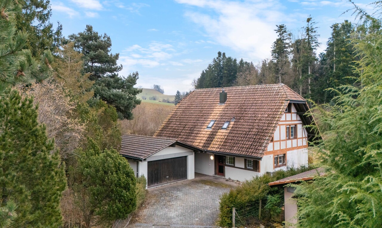 außenansicht mit property visible, day time, garage angeschlossen, stuckverkleidung, und ziegeldach