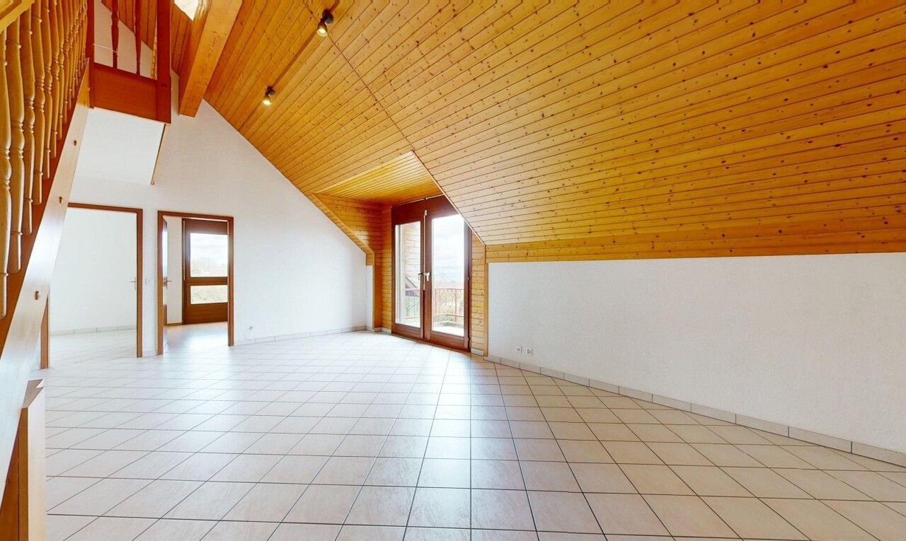 pièce vide avec cloison sèche, plafond en bois, lumière naturelle, et plafond à poutres
