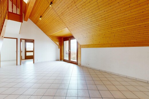 pièce vide avec cloison sèche, plafond en bois, lumière naturelle, et plafond à poutres