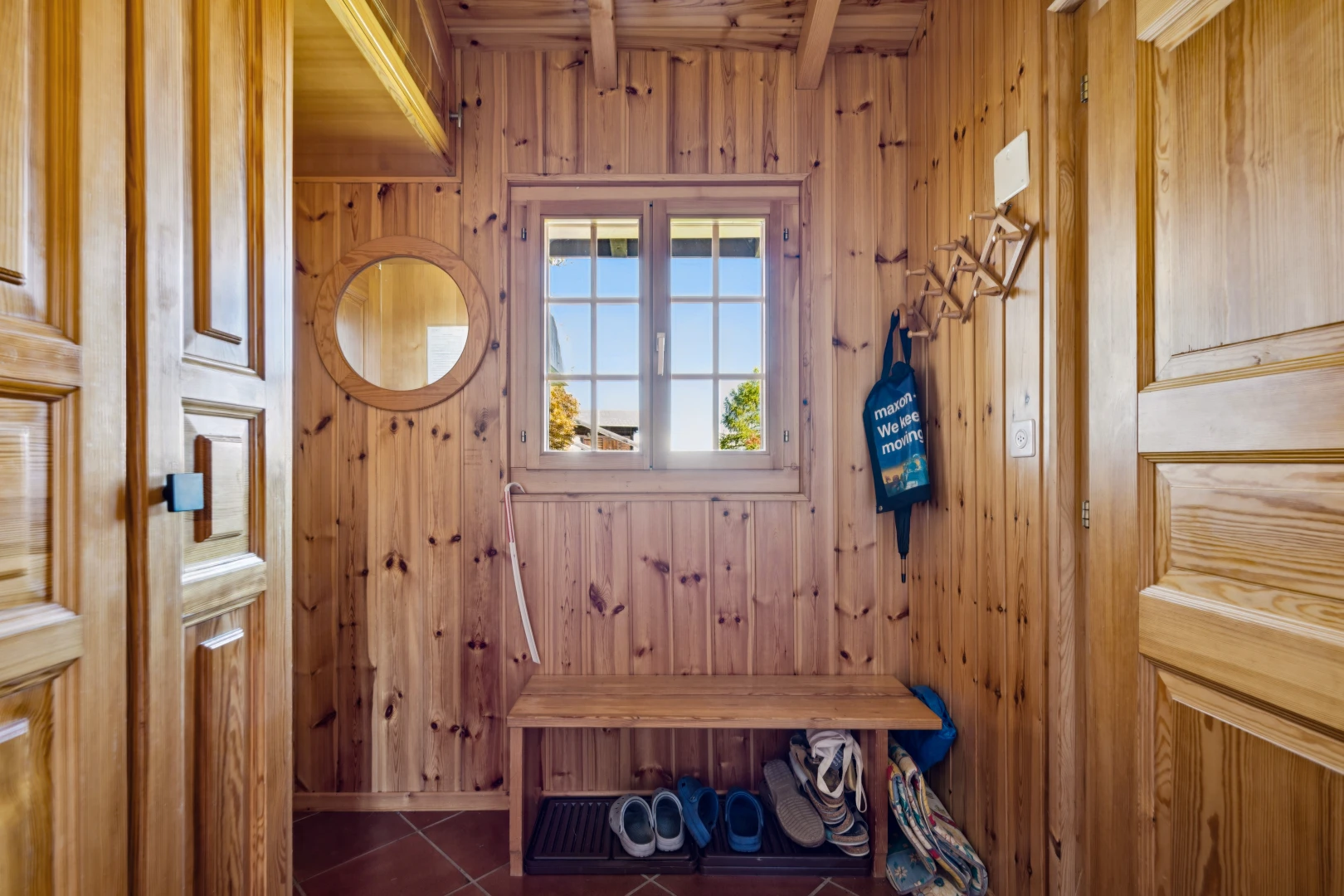 hallway with wooden walls and dark tile patterned floors
