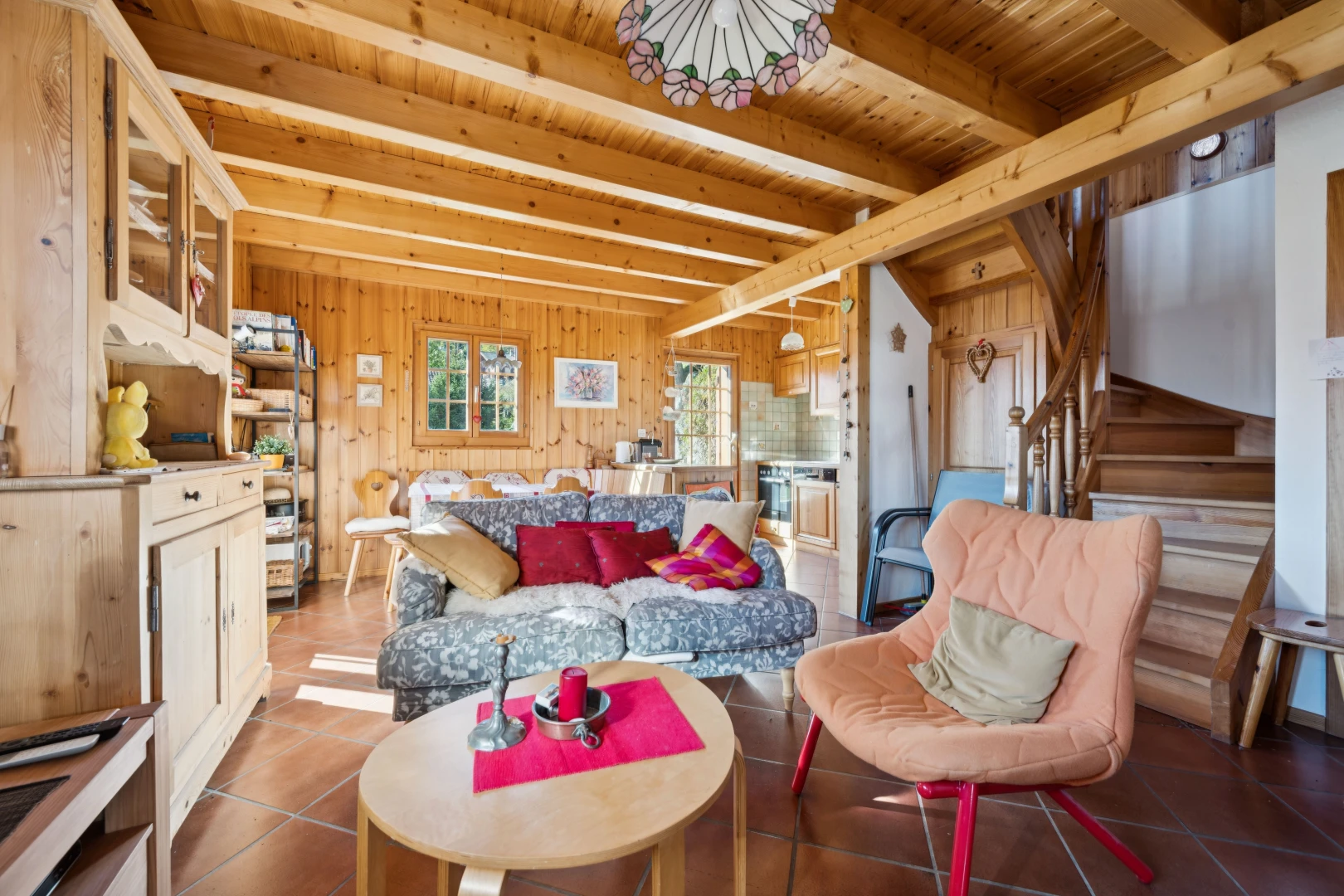 living area featuring a wooden ceiling with exposed beams, tile patterned floors, wooden walls, and pendant lighting