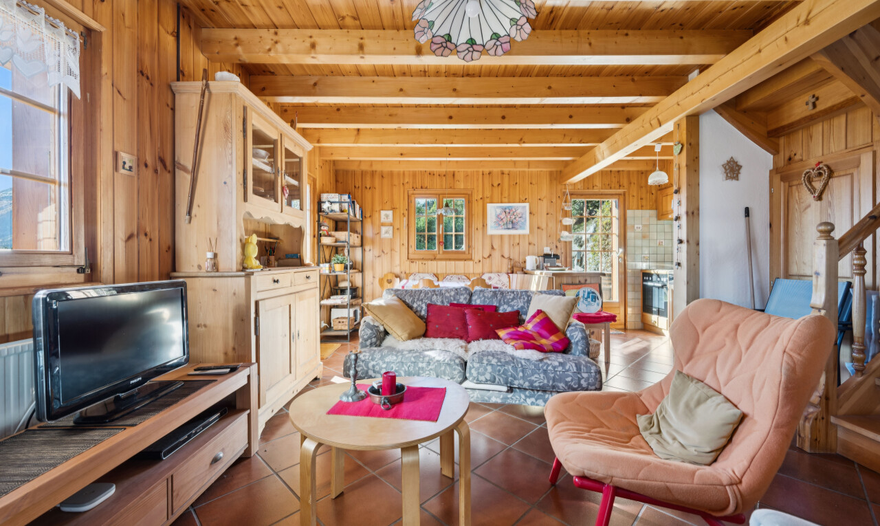 living room featuring wooden walls, hanging light fixtures, a wood ceiling with exposed beams, and dark tile patterned flooring