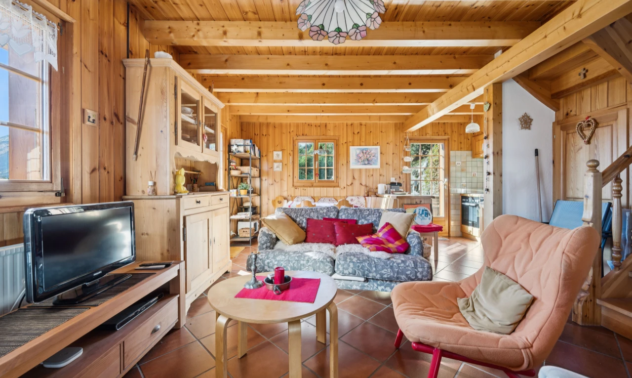 living room featuring wooden walls, hanging light fixtures, a wood ceiling with exposed beams, and dark tile patterned flooring