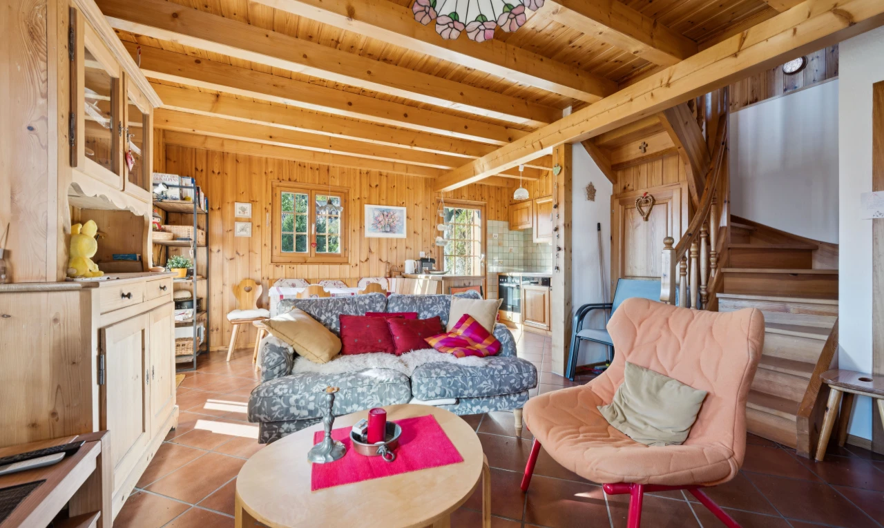 living area featuring a wooden ceiling with exposed beams, tile patterned floors, wooden walls, and pendant lighting