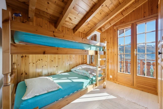 room / bedroom with lofted ceiling with beams, wood ceiling, light wood finished floors, and wooden walls
